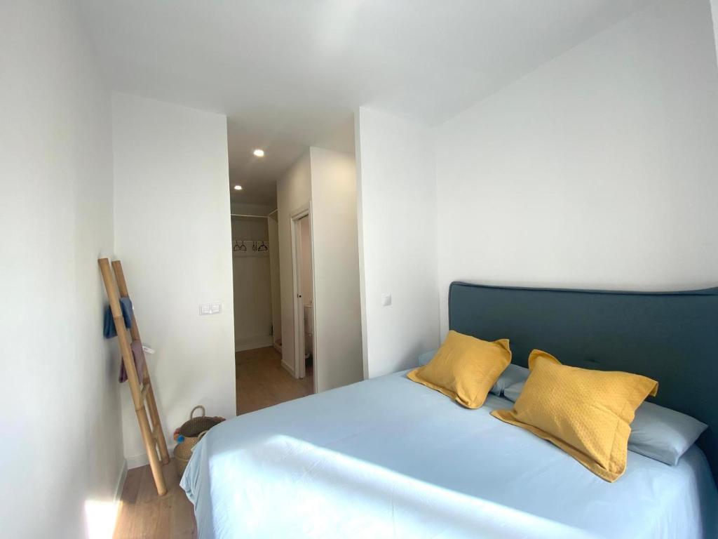 a bedroom with a blue bed with two yellow pillows at El Patio de María in Ferrol