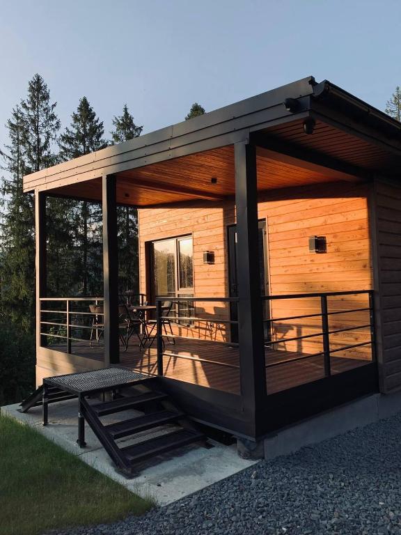 a large wooden cabin with a deck with a table at Love's Mount Resort in Slavske