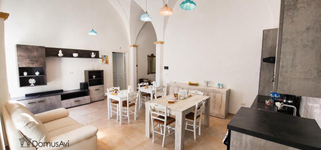 a kitchen and living room with a table and chairs at Domus Avi - Bed and Breakfast in Taviano
