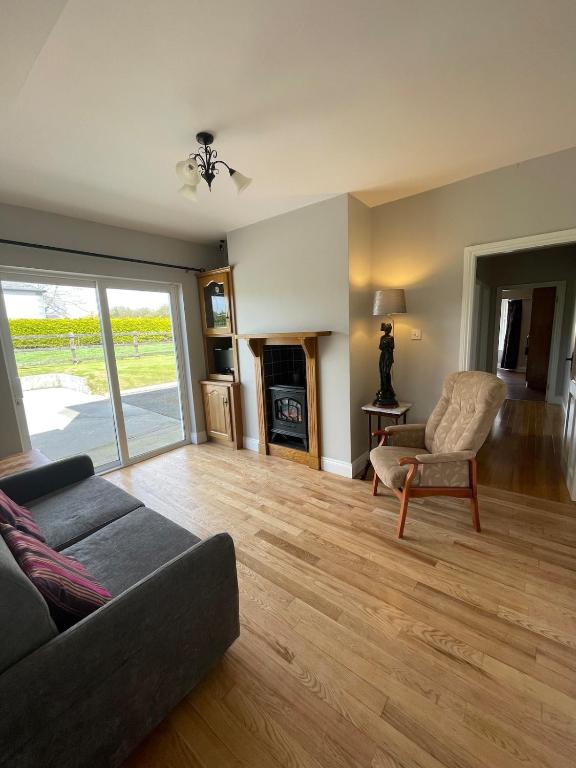 a living room with a couch and a chair and a fireplace at Island Place in Castleisland