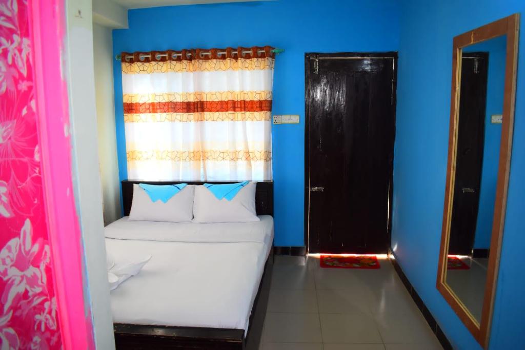 ein kleines Zimmer mit einem Bett und einem Fenster in der Unterkunft Hotel Asad in Mymensingh
