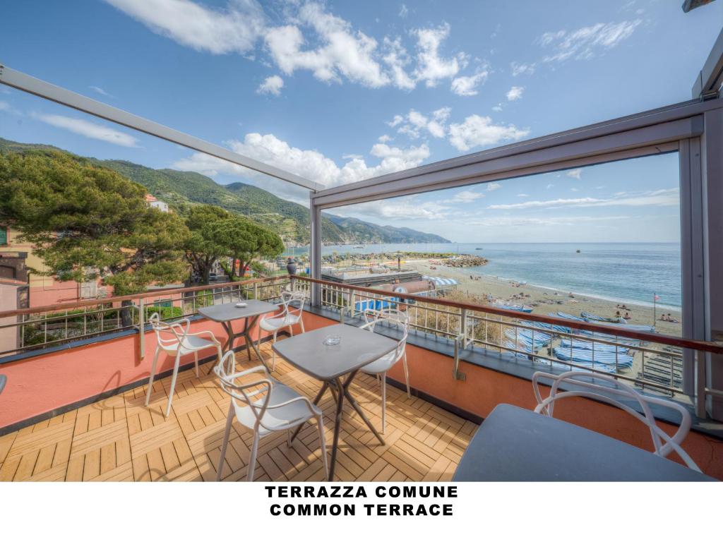 a balcony with tables and chairs and a view of a beach at Affittacamere Lo Scoglio in Monterosso al Mare