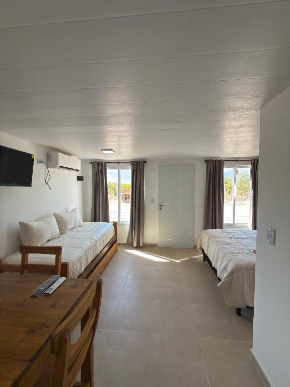 a large room with two beds and a table at Cabañas boutique la soñada BIS in Fiambalá