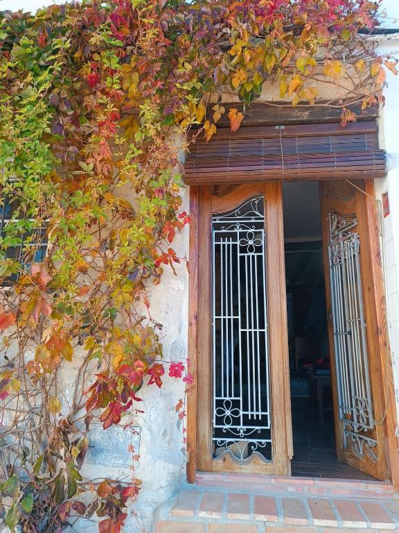 an entrance to a building with a door and flowers at El Bosquet 1897 in Mogente