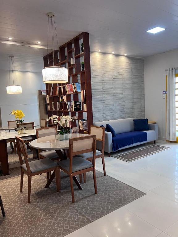 a living room with a table and a blue couch at Casa em vila residencial- excelente localização in Macapá