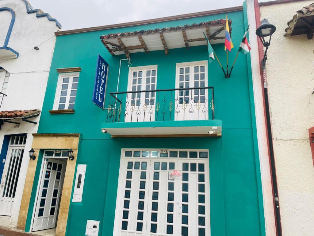 a green building with white windows and a balcony at Hotel Colonial El Bosque A in Tunja