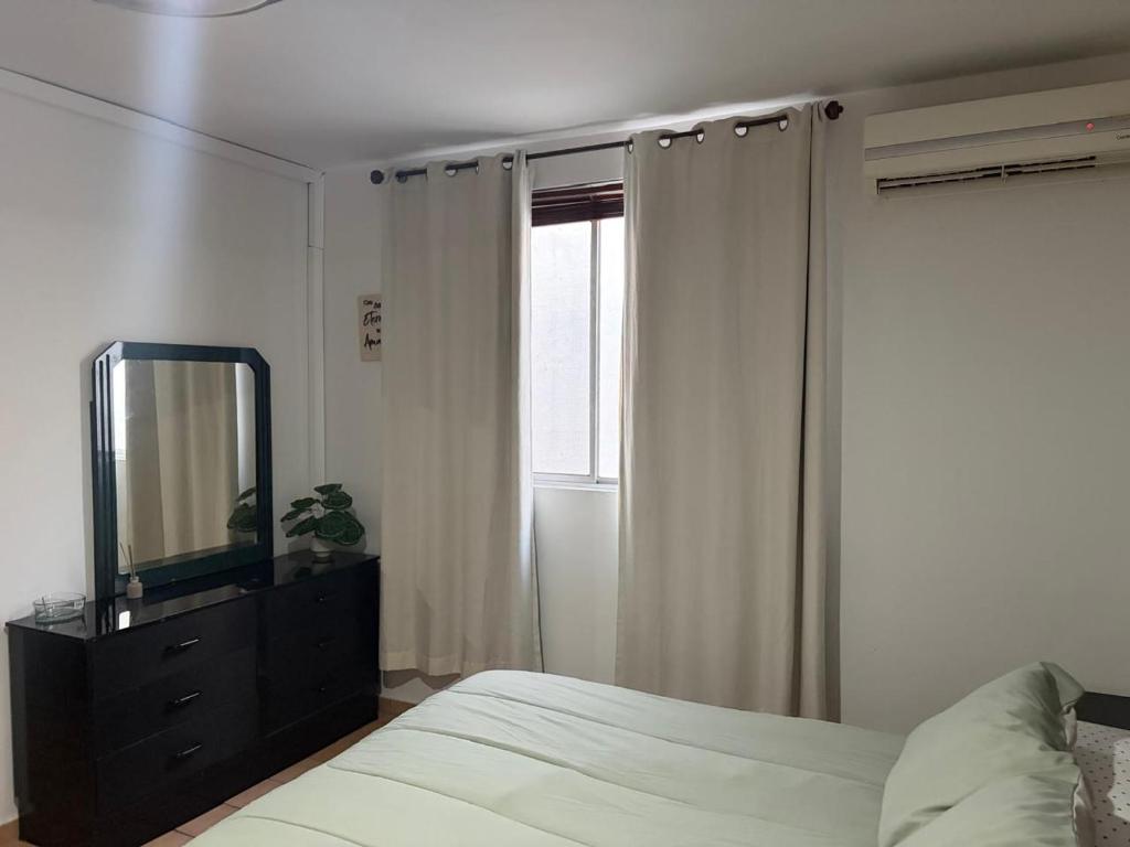 ein Schlafzimmer mit einem Bett mit Spiegel und einer Kommode in der Unterkunft Depa B Bosques del Contry in Monterrey