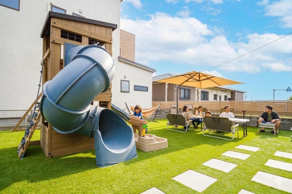 a playground with a slide in a yard at Lapacho 子どもが絶対満足する宿 民泊らぱちょ in Kumamoto