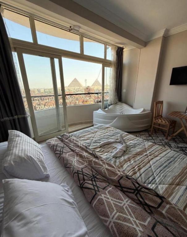 a bedroom with a large bed and a large window at Farida Pyramids inn& Jacuzzi in Cairo