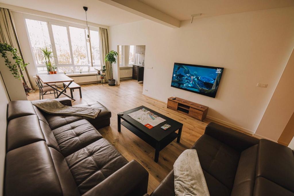 a living room with a couch and a flat screen tv at Cozy vibes deluxe in Antwerp