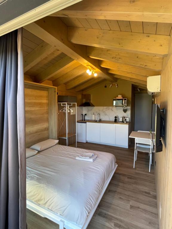 a large bed in a room with a kitchen at Wooden Lodge in Osséja