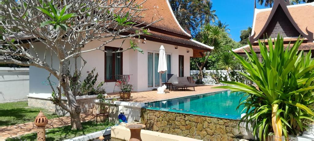 a villa with a swimming pool and a house at Villa Ban Tai Zero, Master Bedroom Bungalow in Nathon Bay