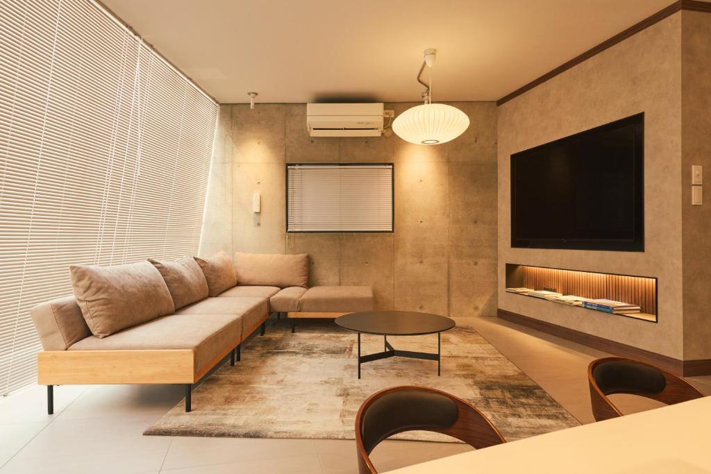 a living room with a couch and a tv at Crane Stay Shibuya in Tokyo