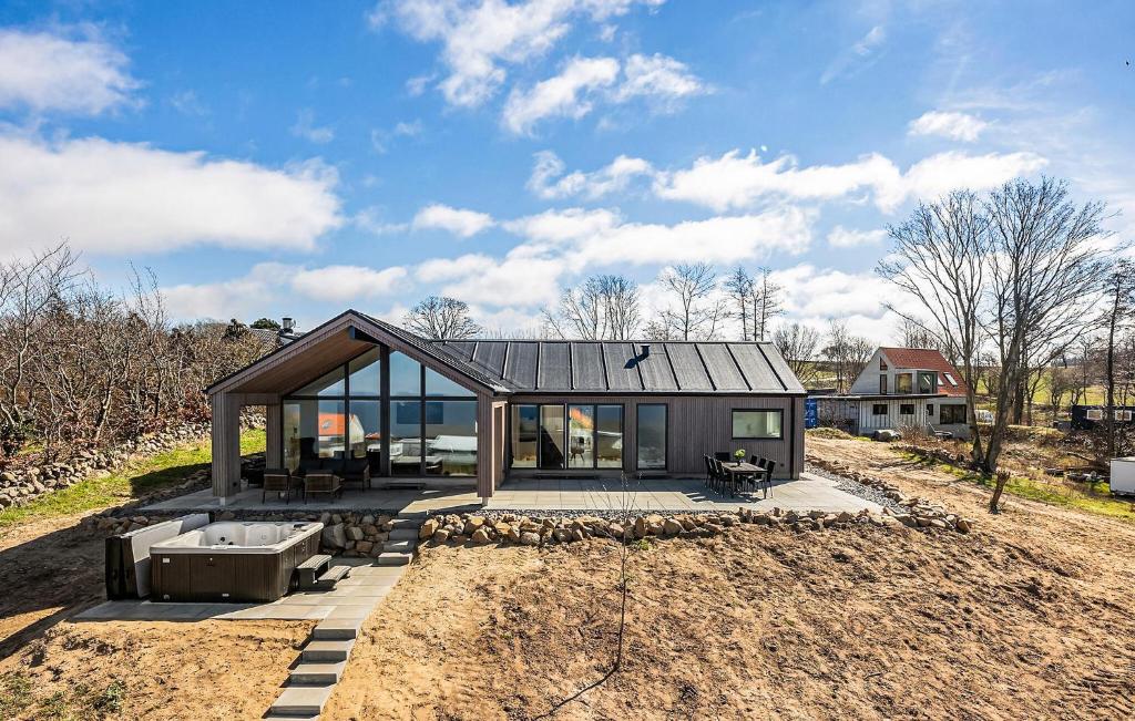 a small house on a dirt field with a sky at Stunning Home In Hasle With Sauna in Hasle