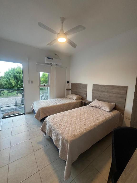 a bedroom with two beds and a ceiling fan at Costumbres Argentinas Dobles En suite in Avellaneda