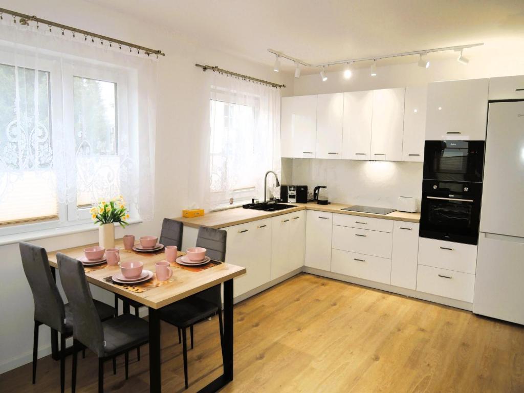a kitchen with a table and chairs and a refrigerator at New apartment in Wise ka in Wisełka