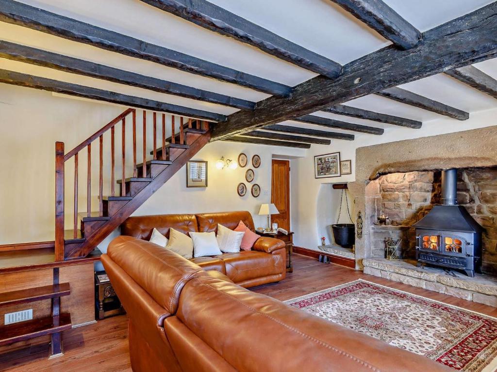 a living room with a leather couch and a fireplace at 2 Bed in Matlock oc-81116 in Crich