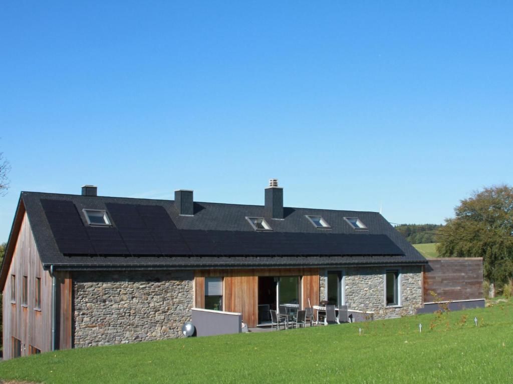 a house with a black roof on a green field at Relax & Play in Ardennes in Morhet