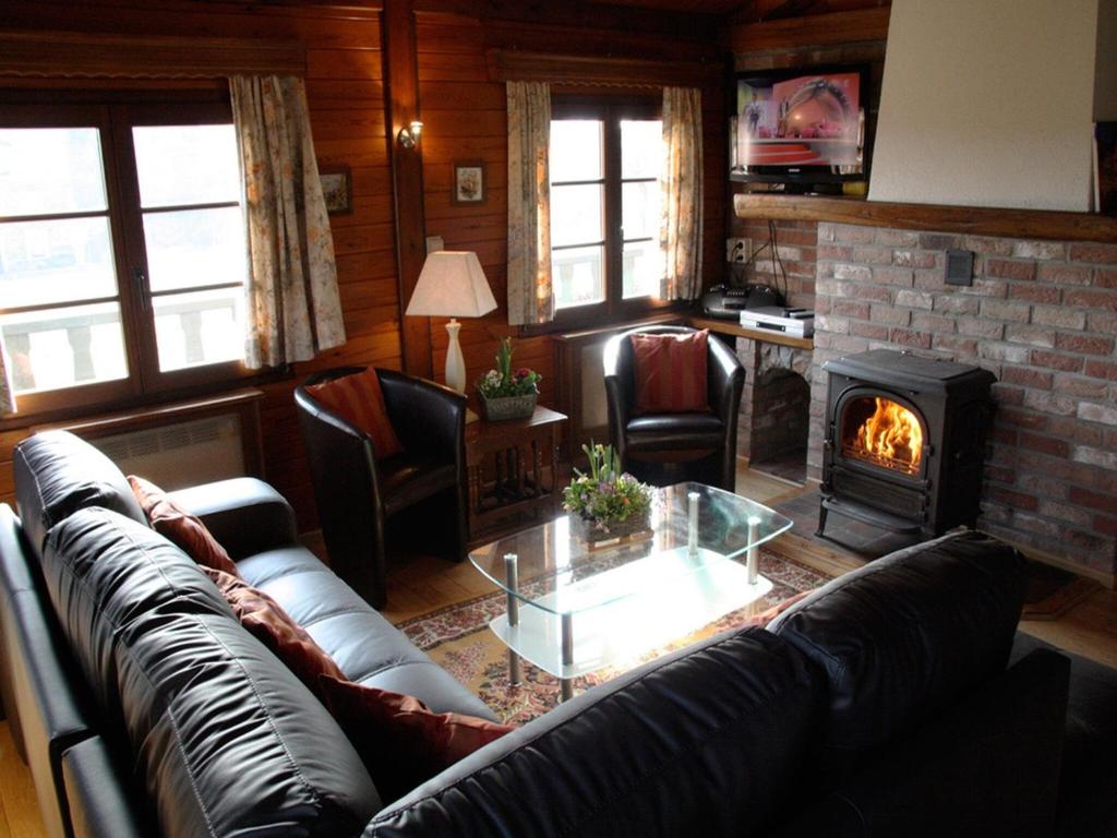 a living room with a couch and a fireplace at Longfaye Chalet with Sauna in Longfaye