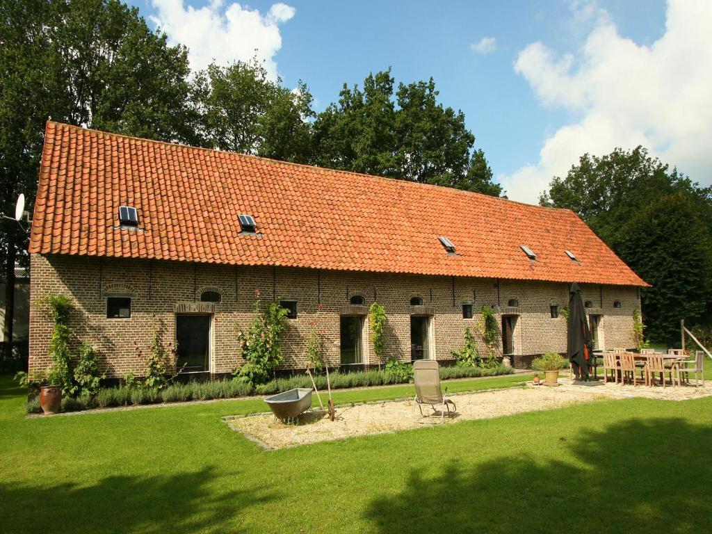 a large brick building with an orange roof at Family Farmhouse with Sauna in Beernem