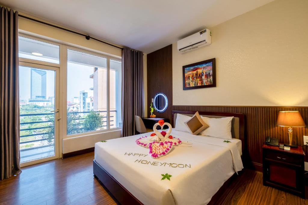 a hotel room with a bed with a crown on it at Baly Hotel Hue in Hue