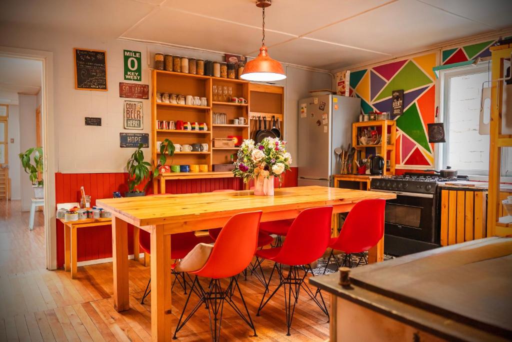 a kitchen with a wooden table and red chairs at Isla Yu Patagonia 2 in Puerto Natales