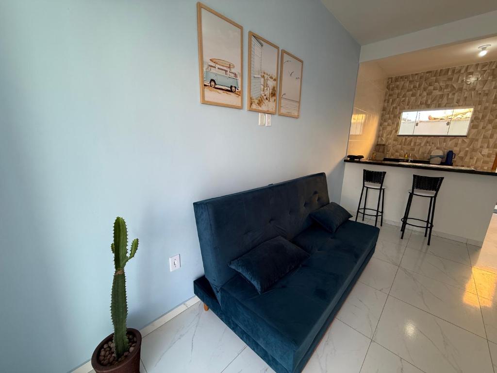 a blue couch in a living room with a cactus at Mar Azul Beach House in Cabo Frio