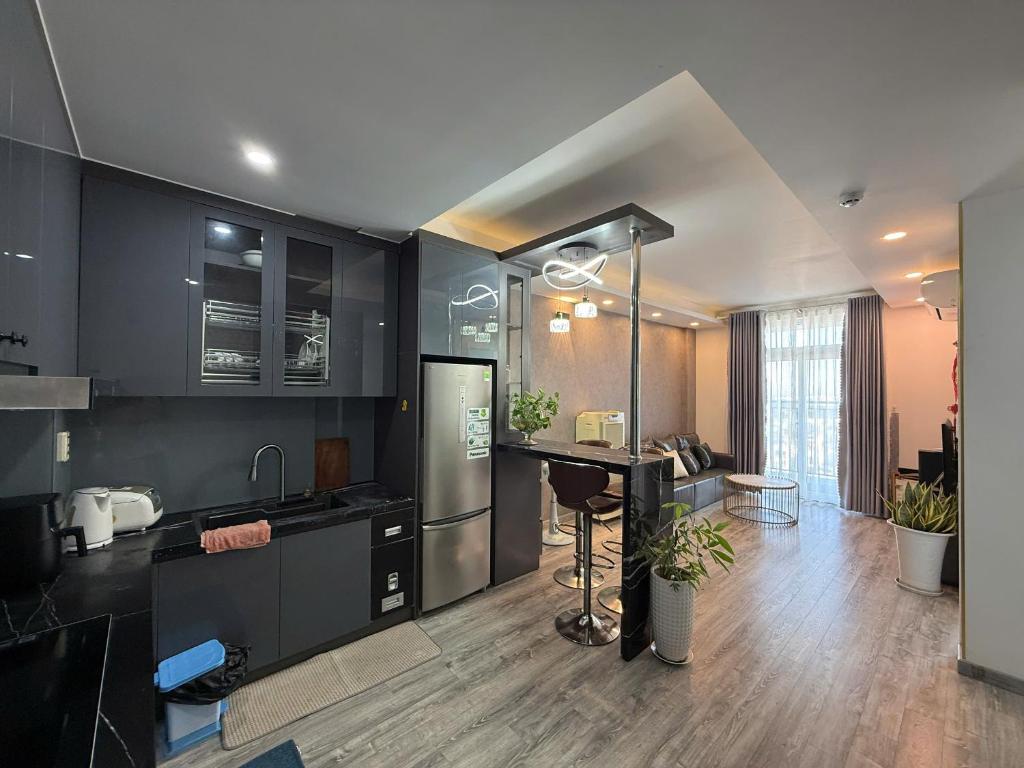 a kitchen with black cabinets and a kitchen island at Sun's house in Phan Rang–Tháp Chàm