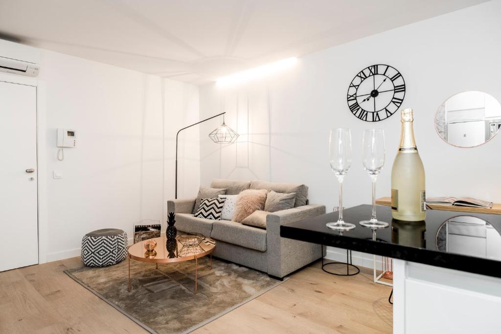 ein Wohnzimmer mit einem Sofa und einem Tisch in der Unterkunft BNBHolder Luxury Apartment II PLAZA DE ESPAÑA in Madrid
