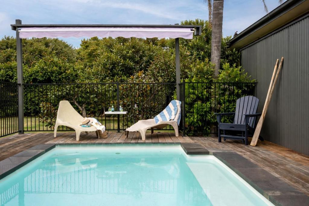 a swimming pool with two chairs and a table at Salty Breeze on Graeme in Dromana