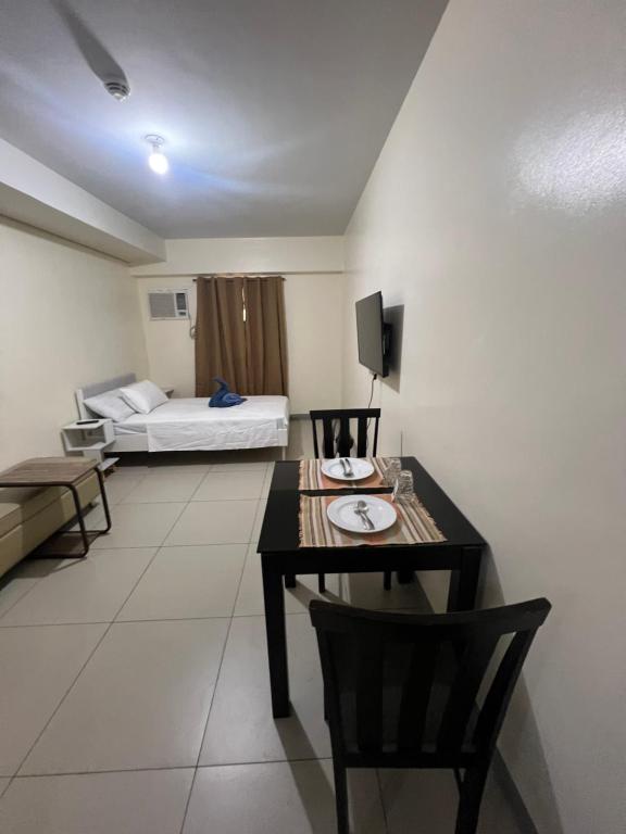 a room with a table and a bed in a room at Studio 7 in Manila
