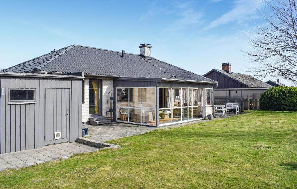 a house with a garage and a grass yard at Lovely Home In Simrishamn With Wifi in Simrishamn