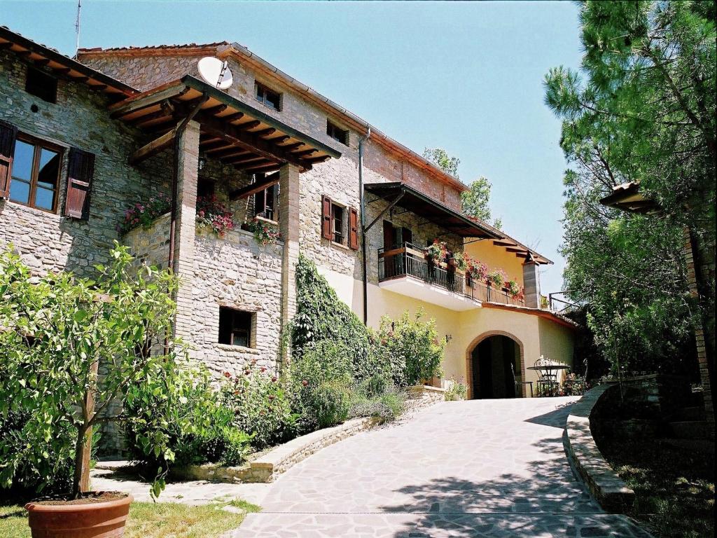 a building with flowers on the balconies of it at Farmhouse in Umbria near Palazzo Bourbon in Monte Santa Maria Tiberina