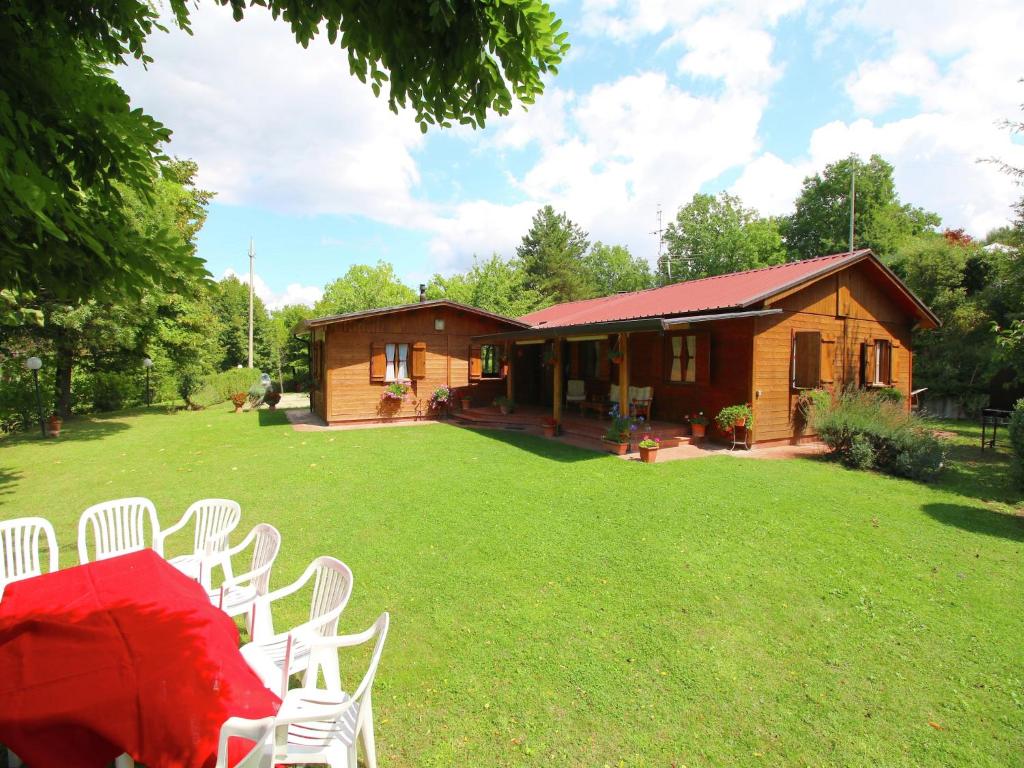 a group of white chairs sitting on a lawn in front of a house at Chalet in Umbria with Private Pool in Città di Castello