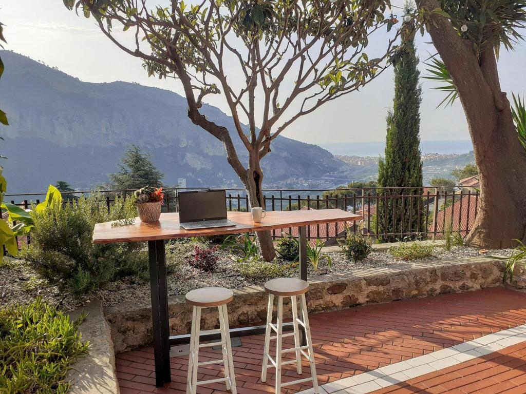 a table with a laptop on it with two stools at family Stay in French Riviera in Ventimiglia
