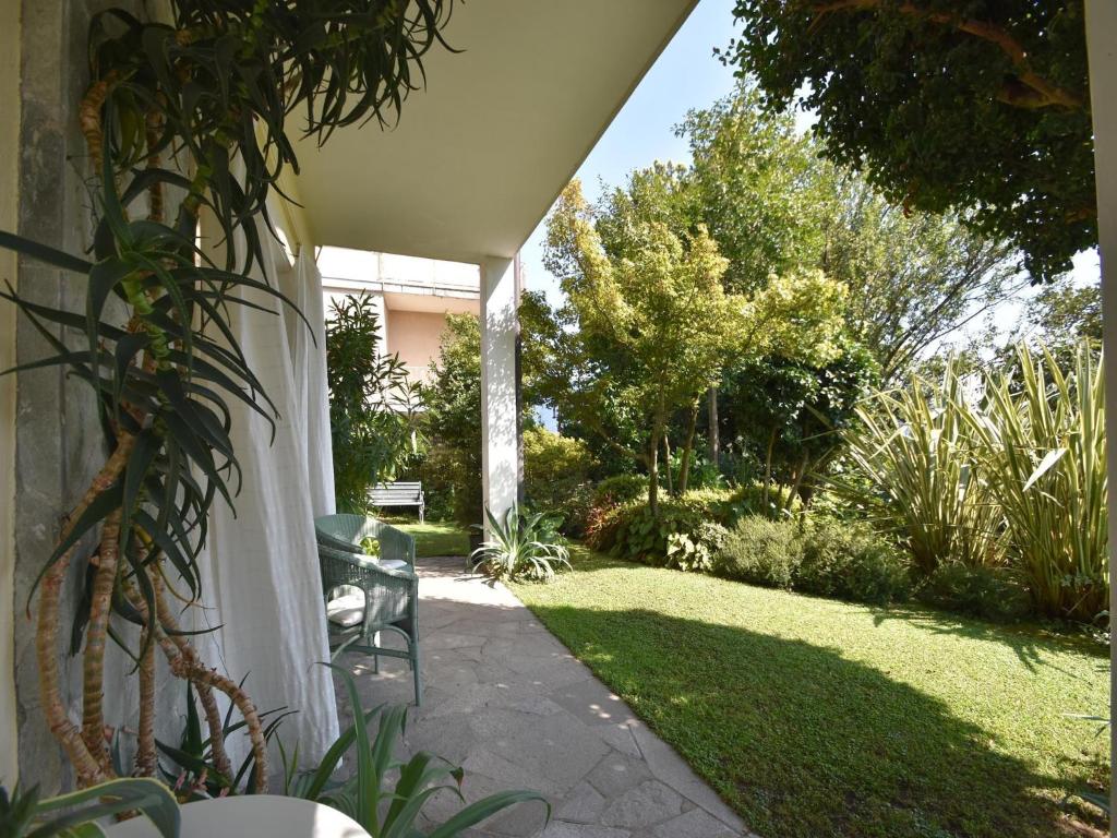a patio with a lawn with a chair on it at Chalet by Lake Maggiore with Garden Views in Verbania