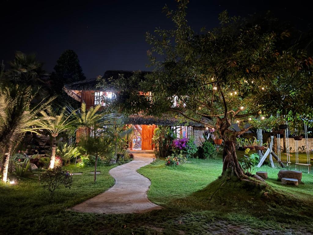 a garden at night with a tree and a path at Núi Dinh Stilt House - Phú Mỹ in Ấp Long Cát