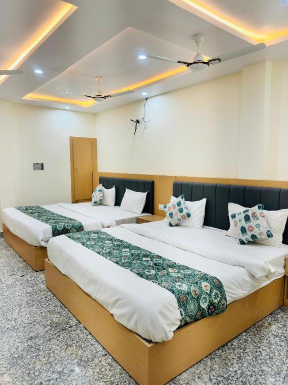 a row of three beds in a room at HOTEL SHIVAAY near by urban Square mall and nexus celebration mall in Bedla