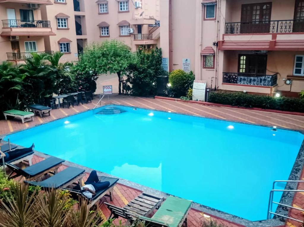 a large swimming pool in front of a building at 1 Bhk apartment kyle garden baga beech in Baga