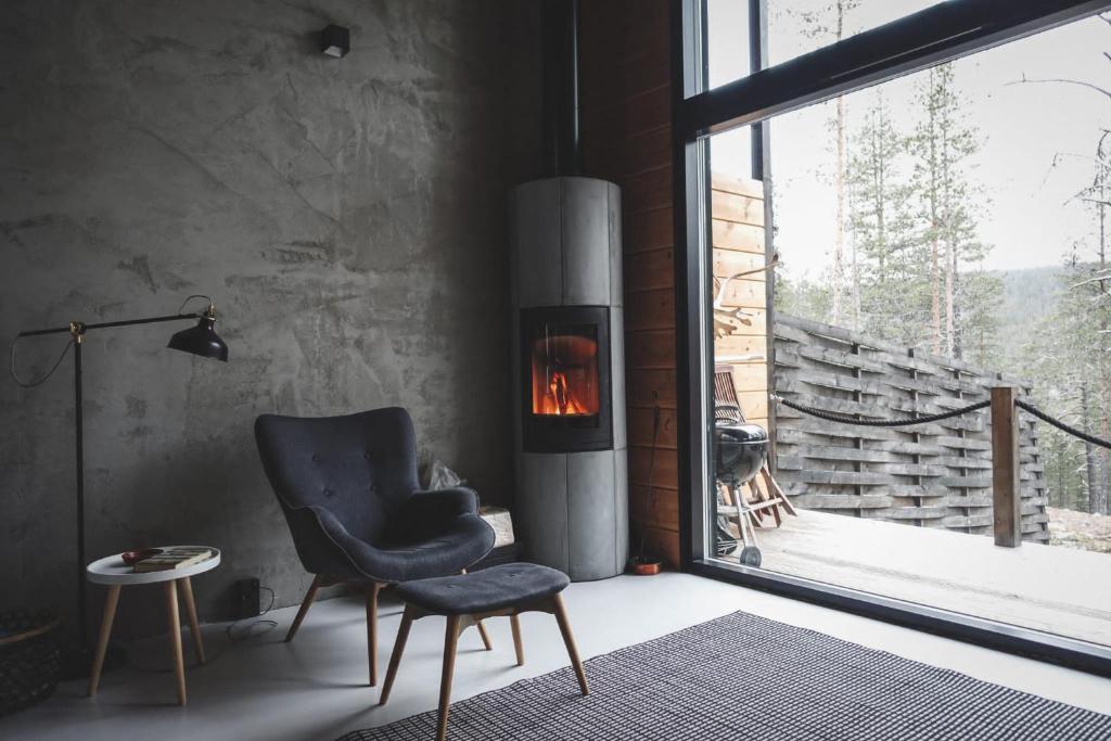a living room with a chair and a fireplace at Lapin Unelma in Äkäslompolo