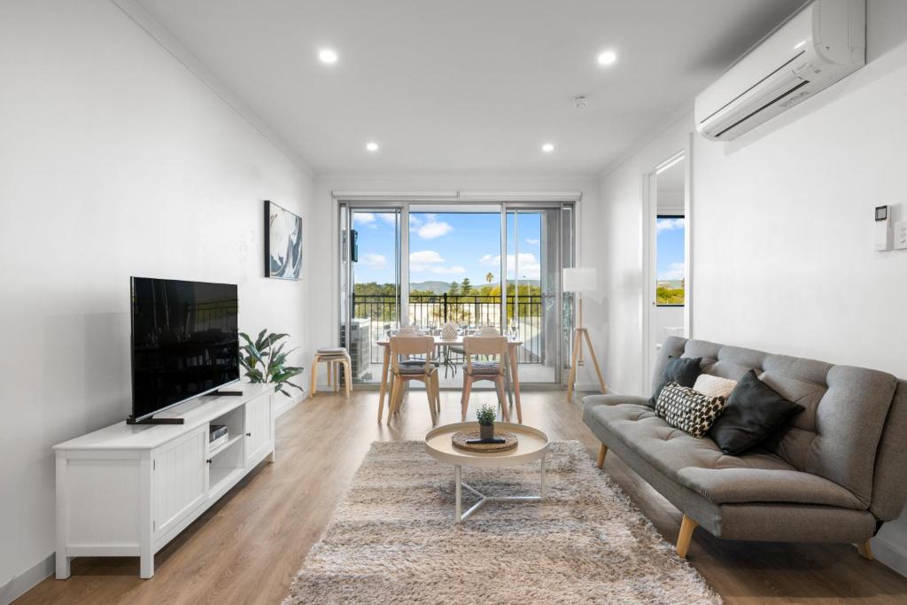 a living room with a couch and a tv and a table at Elevated 2BR & Sofa Bed Apartment in the Heart of Prospect in Prospect