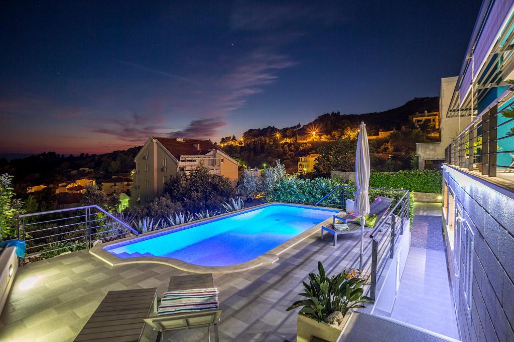 a swimming pool on the side of a building at night at Villa Steffi in Baška Voda