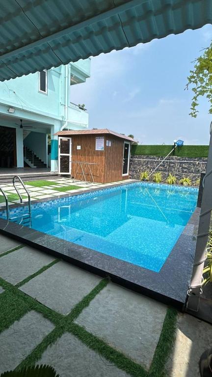 a swimming pool in front of a house at sun vacation resort in Visakhapatnam