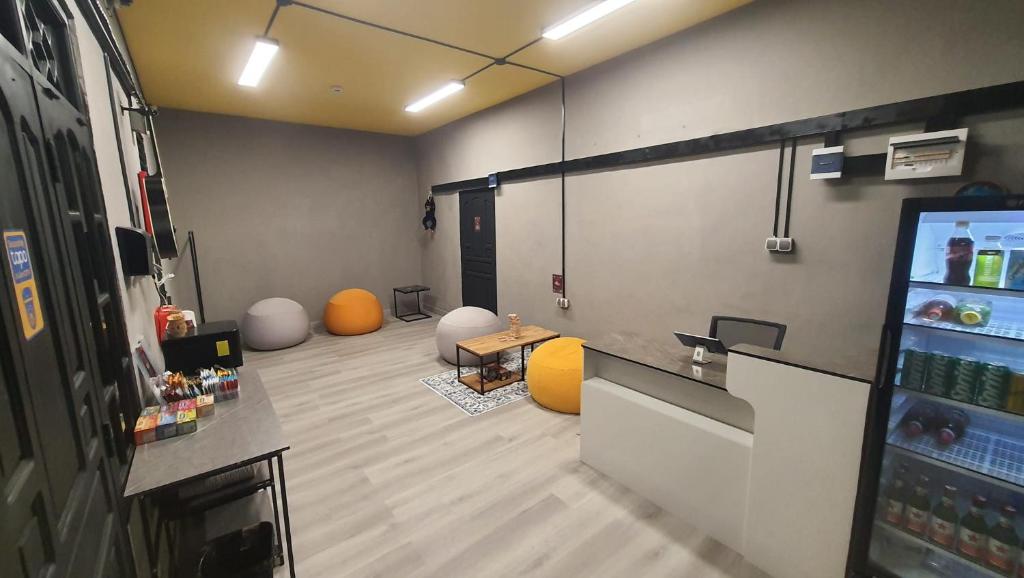 a room with a bar with orange chairs and a screen at Yellow Monkey Hostel Uluwatu in Uluwatu