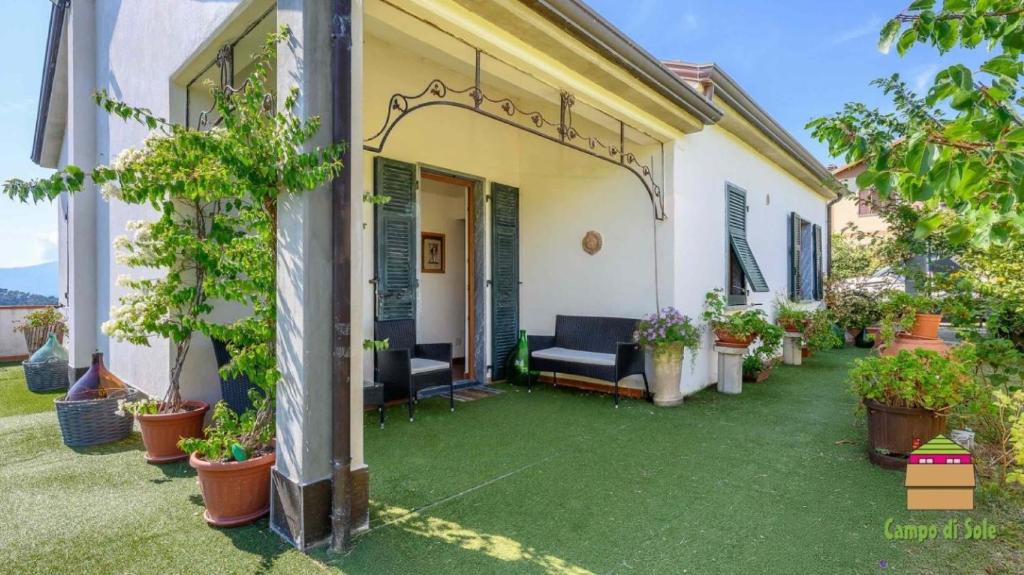 a house with a green yard with potted plants at In Vino Veritas B&B in Arcola
