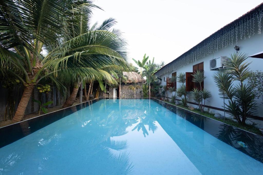 a large blue swimming pool next to a building at Banyan Villa Nha Trang in Nha Trang