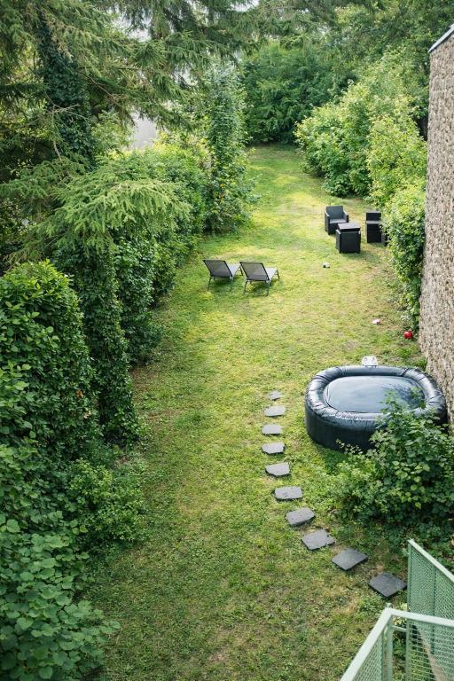 a backyard with a swimming pool and a tire on the grass at Spa Sauna et jardin 47m2 Cosy hyper centre in Boulogne-sur-Mer