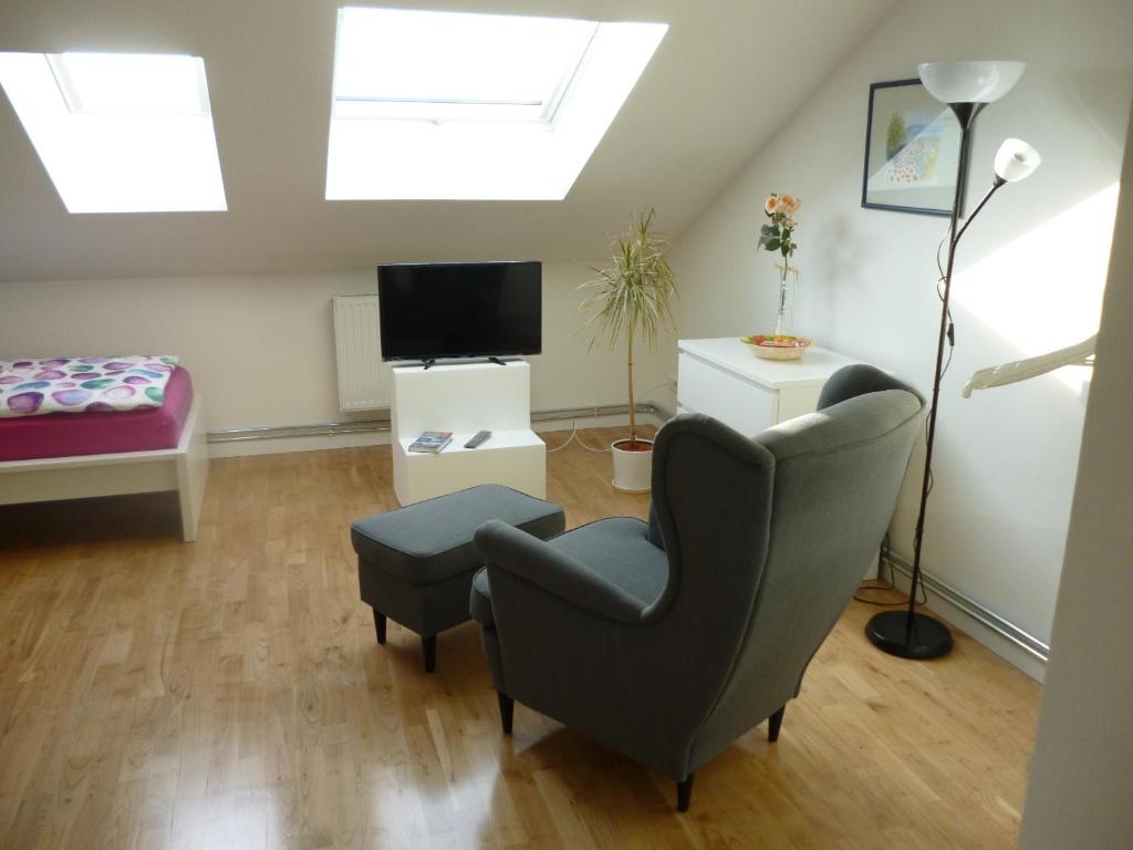 ein Wohnzimmer mit einem Stuhl und einem TV in der Unterkunft A10 Apartmenthaus in Rangsdorf