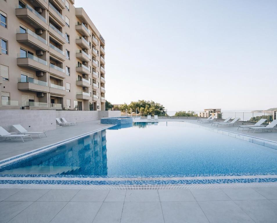 a swimming pool in front of a building at Status S in Bečići