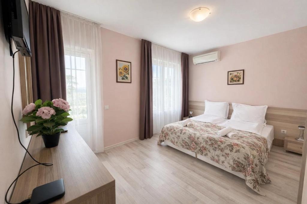 a hotel room with a bed and a television at Къщата с чешмата in Veliko Tŭrnovo